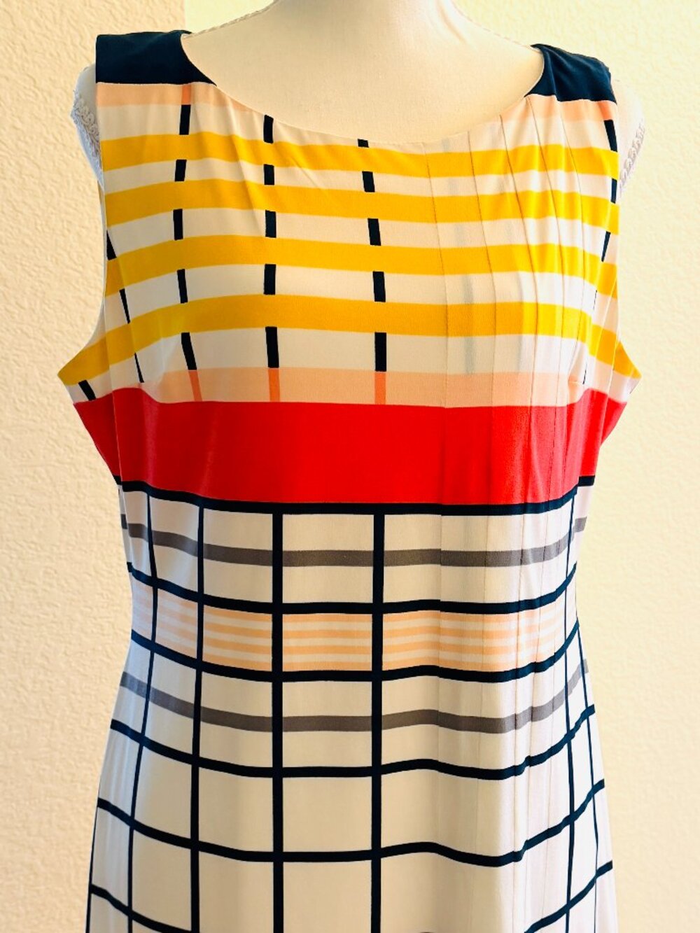 Sleeveless shift dress features an eye-catching geometric windowpane grid patter